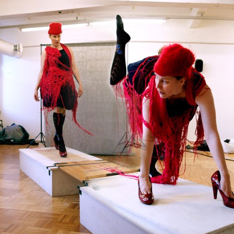 Kuvassa punahattuinen nainen esiintyy Catwalkilla.